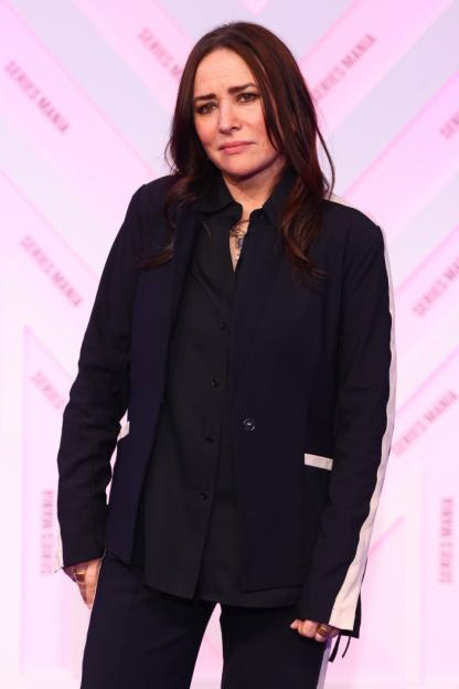 A woman with long dark hair wearing a black shirt and dark blue blazer at the Series Mania 2025 Closing Ceremony.