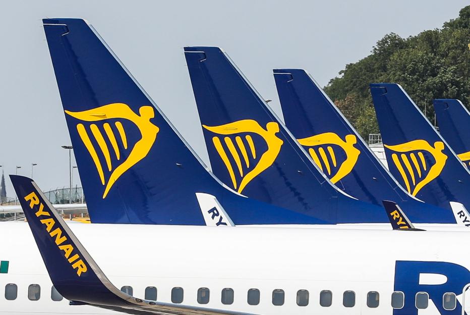 Ryanair airplanes with the harp logo on their tails parked on the tarmac.