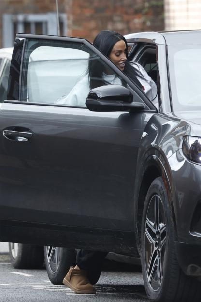 Katie Price exiting a gray car in brown boots.