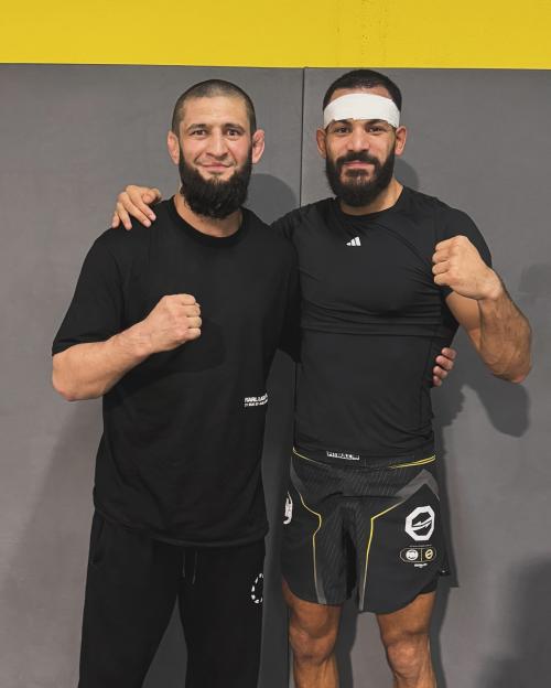 Khamzat Chimaev and Ediz Tasci standing together, smiling at the camera.