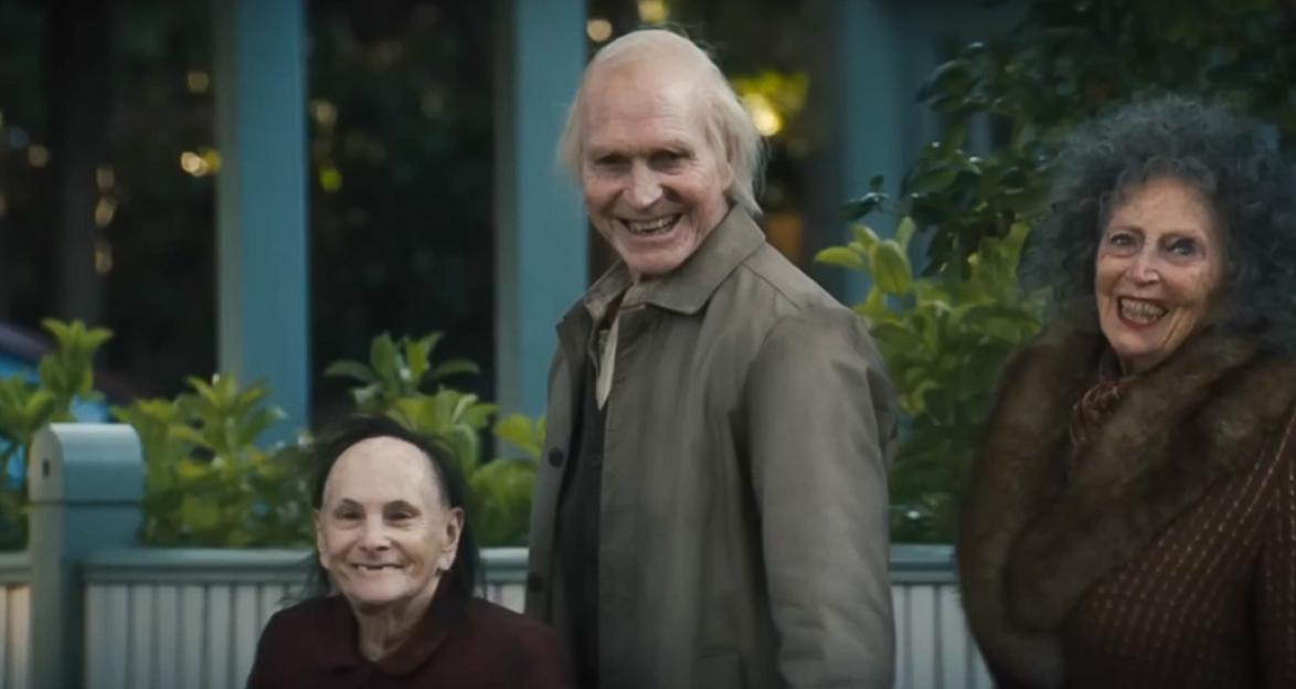 Three elderly individuals, two women and one man, smiling.