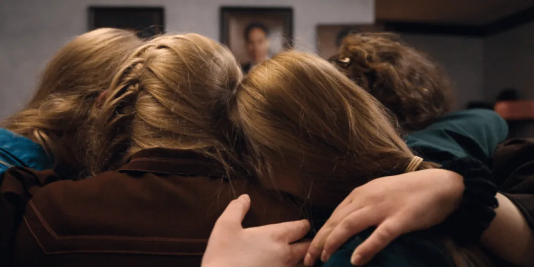 Four people embracing each other in a tight huddle.