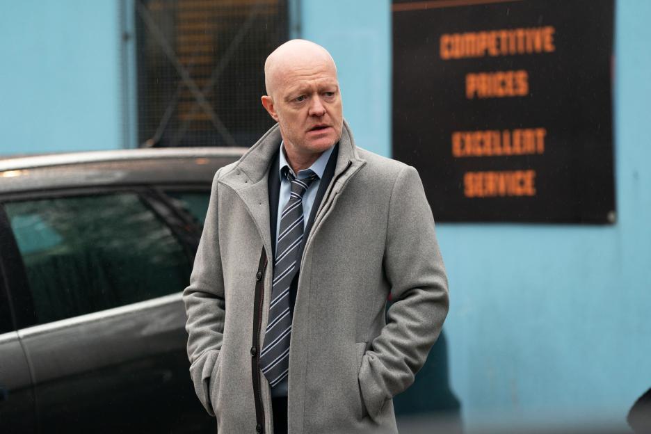 Max Branning (Jake Wood) in a grey coat and striped tie, looking to the side.