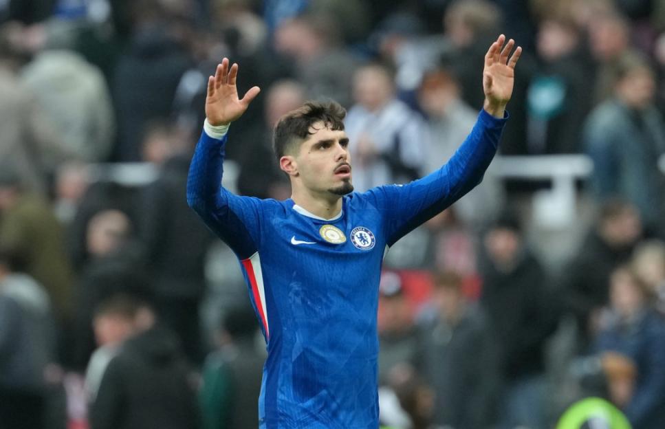 Chelsea player Kenedy raising his arms during a Premier League match.
