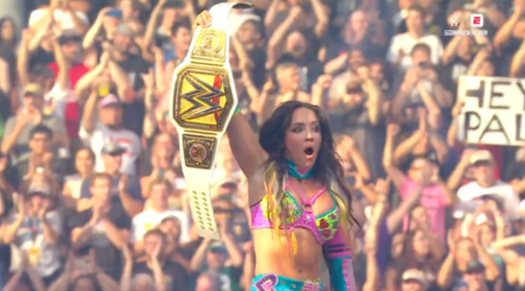Wrestler AJ Lee holding up the WWE Divas Championship belt at SummerSlam.