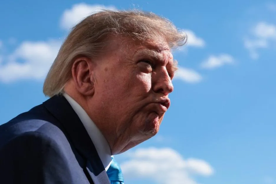 U.S. President Donald Trump speaks and points forward during a campaign rally.