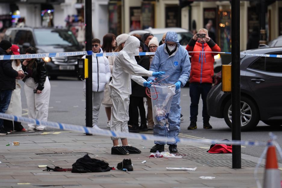 Forensic investigators collecting evidence at the scene on Shaftesbury Avenue in central London.