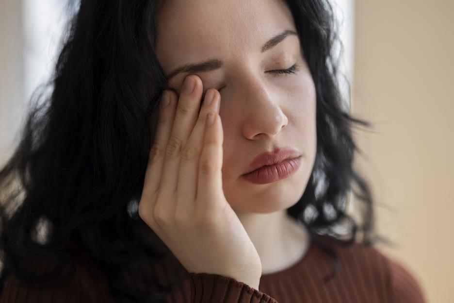 Young Woman Rubbing Tired Eyes Feeling Exhausted and Stressed at Home
