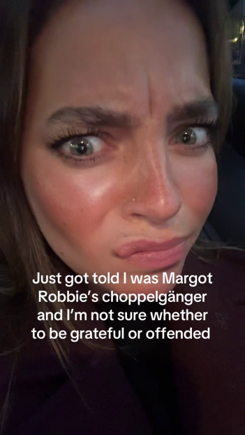 A woman with wide eyes and pursed lips looking at the camera, with text "Just got told I was Margot Robbie's choppelgänger and I'm not sure whether to be grateful or offended."