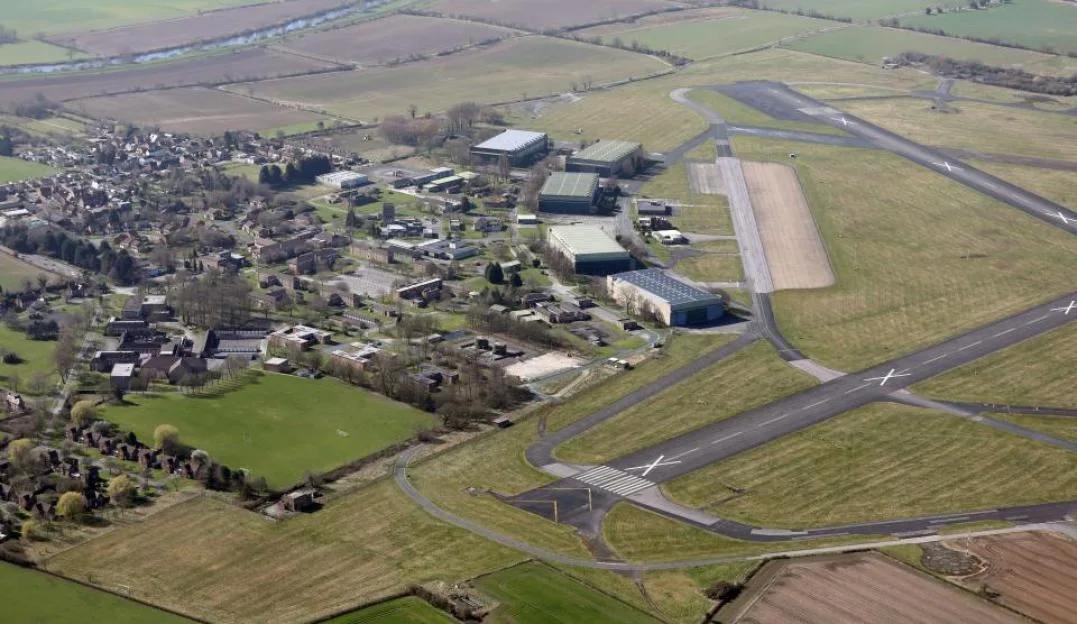Aerial view of the now-closed RAF Linton-On-Ouse air force base, showing its runways, hangars, and surrounding buildings near York, North Yorkshire.