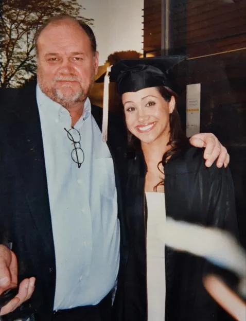 Thomas Markle poses with Meghan Markle in her graduation cap and gown.