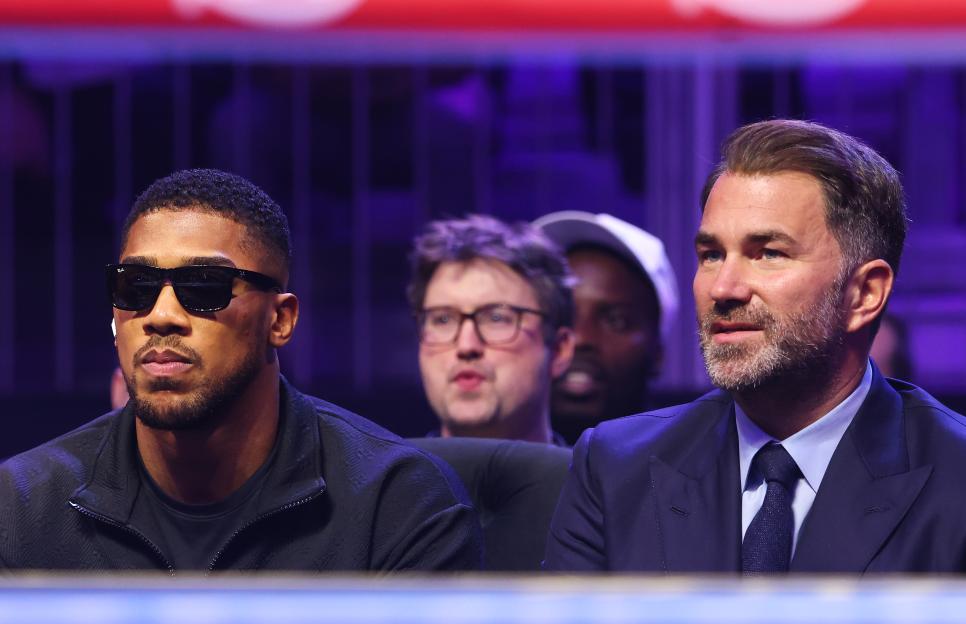 Anthony Joshua and Eddie Hearn watching a boxing match.