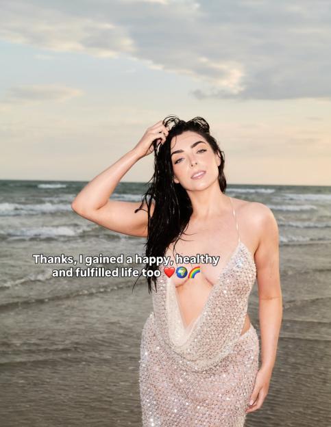 Nelly London posing on the beach with wet hair, wearing a sparkly dress with a deep V-neck, with text overlay "Thanks, I gained a happy, healthy and fulfilled life too."