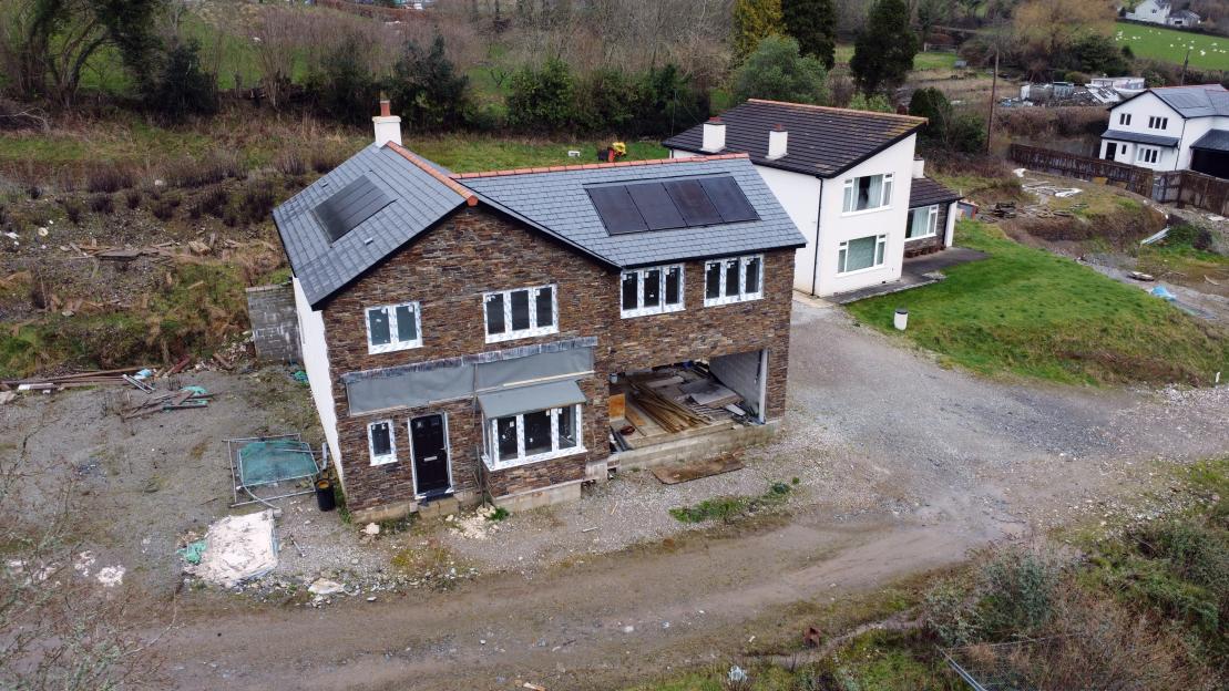 Aerial view of an abandoned new-build estate with houses in various stages of completion.