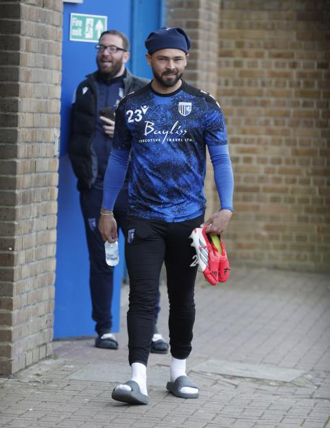 Bradley Dack walking in an athletic outfit, holding cleats and a water bottle, with no wedding ring on his left hand.