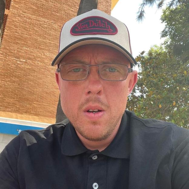 Man wearing a Von Dutch hat and glasses.