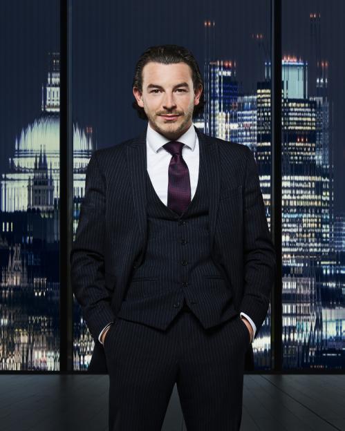 Kieran McCartney, a candidate on The Apprentice, wearing a pinstripe suit and purple tie.