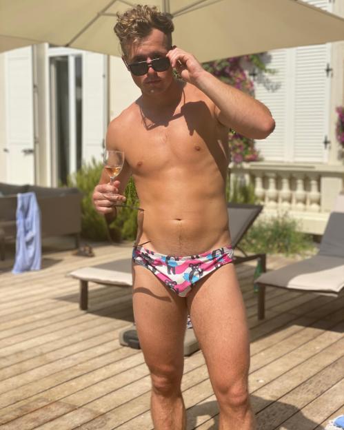 Chris Easto, Ekin-Su's secret boyfriend, posing in swim trunks and sunglasses with a drink in hand.