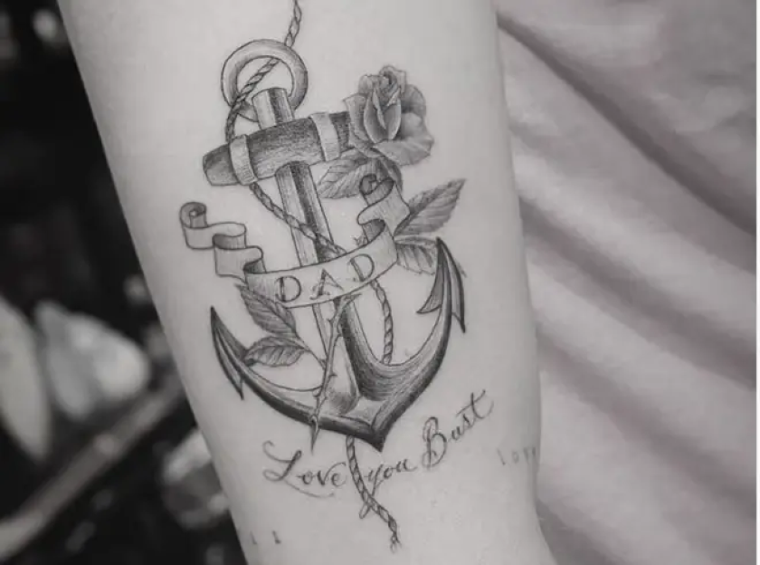 Tattoo of an anchor with "DAD" written on a banner, a rose, and the words "Love you Bust" below it.