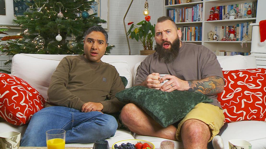 Joe Marler and Nick Mohammed on Celebrity Gogglebox, watching TV with surprised expressions.