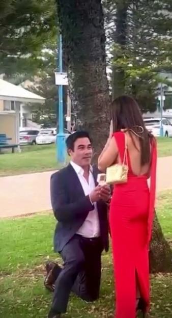 A man proposing to a woman outdoors.