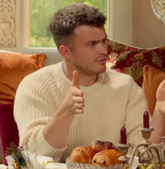 Reece looking to his right with a questioning expression.