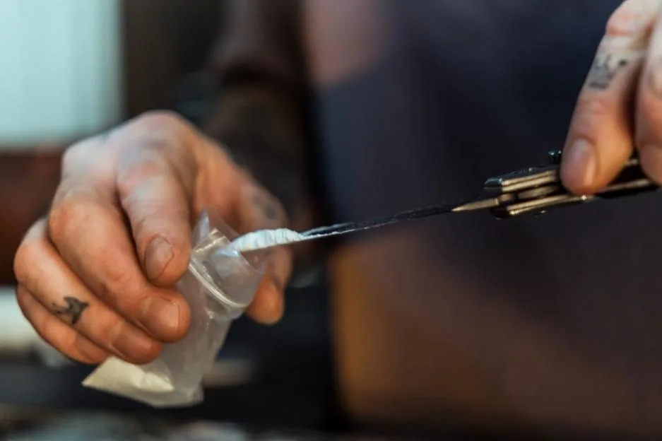 Hands putting cocaine into small bag