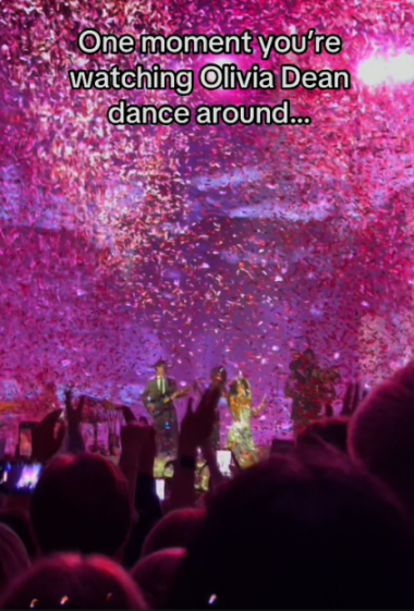 Olivia Dean performing on stage with confetti cannons.
