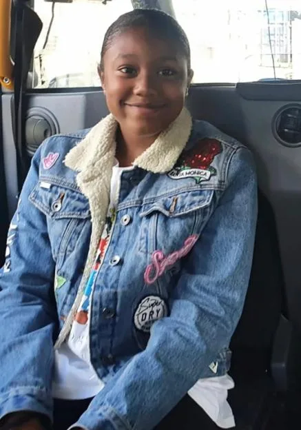 Mia Shay St Hilaire smiling in the back seat of a vehicle.