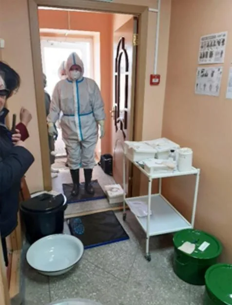 A person in full protective gear stands in a doorway during a plague-response drill at the Russia-Mongolia border.