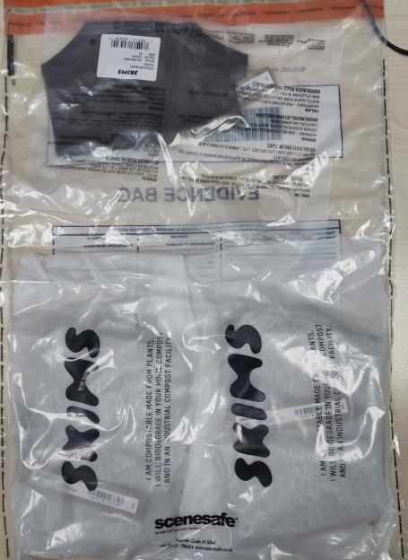 Two clear plastic evidence bags containing sealed packages of Skims underwear.