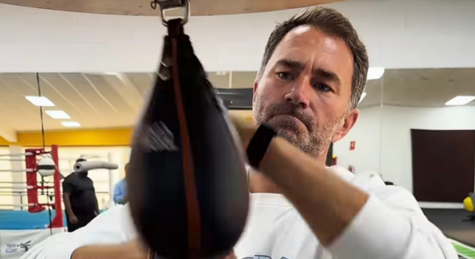 A man with a beard punching a speed bag in a gym.