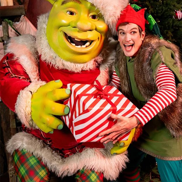 Shrek dressed as Santa and an elf holding a Christmas present.