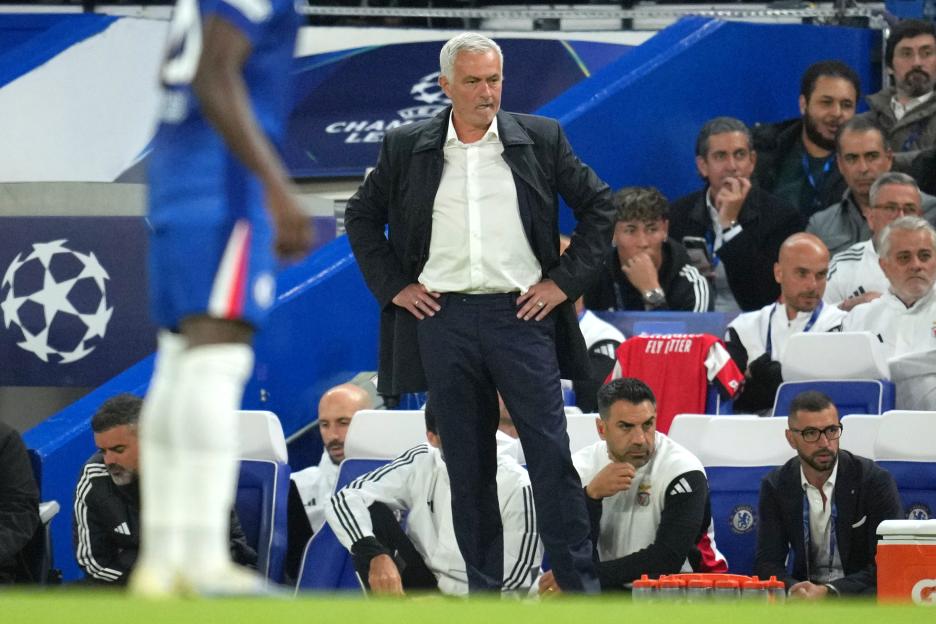 José Mourinho, head coach of Benfica, standing on the sidelines at a soccer match.