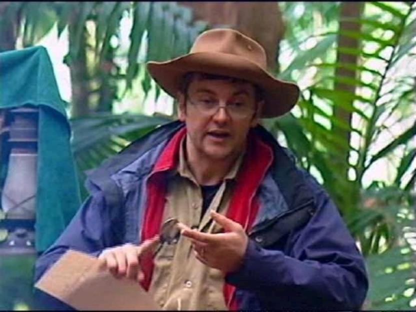 Joe Pasquale in the jungle, holding a small object in his hands.