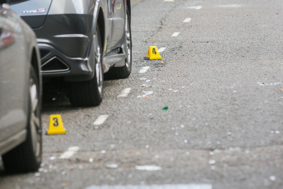 Police evidence markers #3 and #4 on a street next to cars.