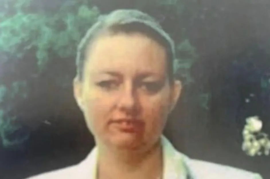 A close-up of a woman looking directly at the camera, with a slight smile.