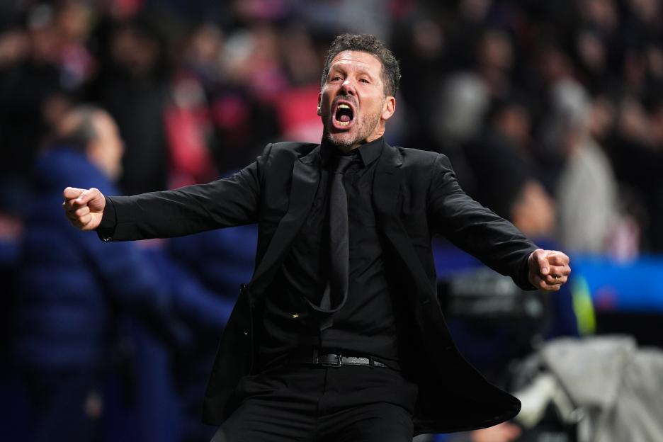Atlético de Madrid coach Diego Simeone shouts with his arms outstretched during a UEFA Champions League match.