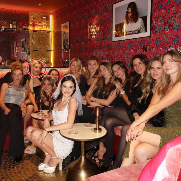Victoria Beckham, with ten other women, at a bar.