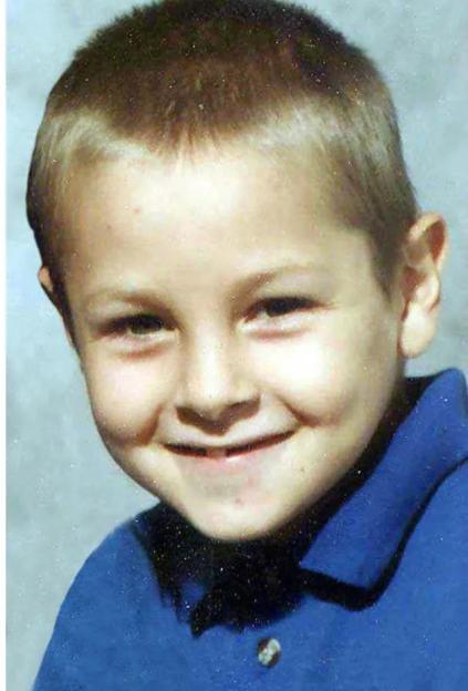 Jamie Lavis, a young boy with short hair, smiling while wearing a blue collared shirt.