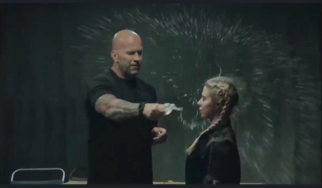 A man spraying water from a bottle onto a woman's face.