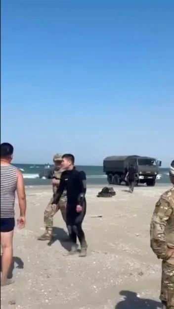 Military personnel and vehicles at a beach on the Caspian Sea during a military drill.