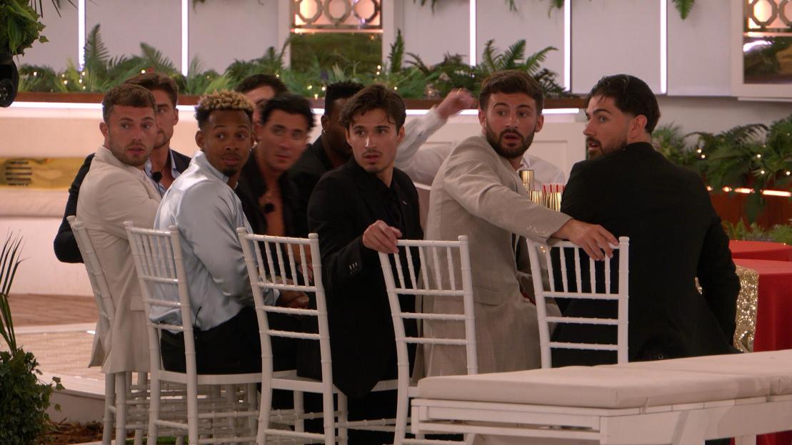 The Love Island boys watching a performance with surprised expressions.
