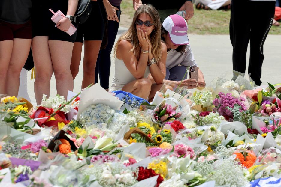 Mourners gather by floral tributes at Bondi Pavillion.