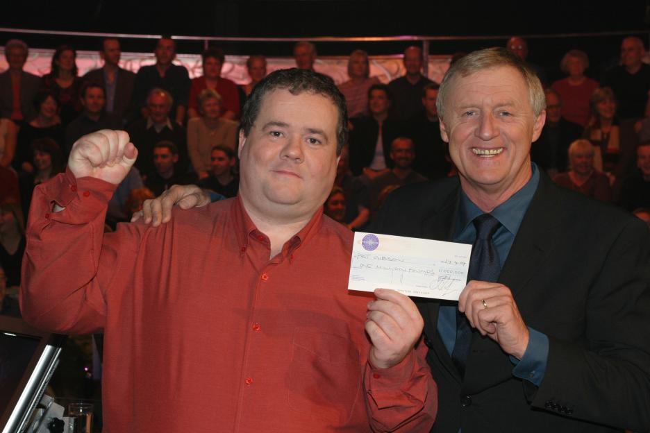 Pat Gibson and Who Wants To Be A Millionaire host Chris Tarrant holding a check for one million pounds.