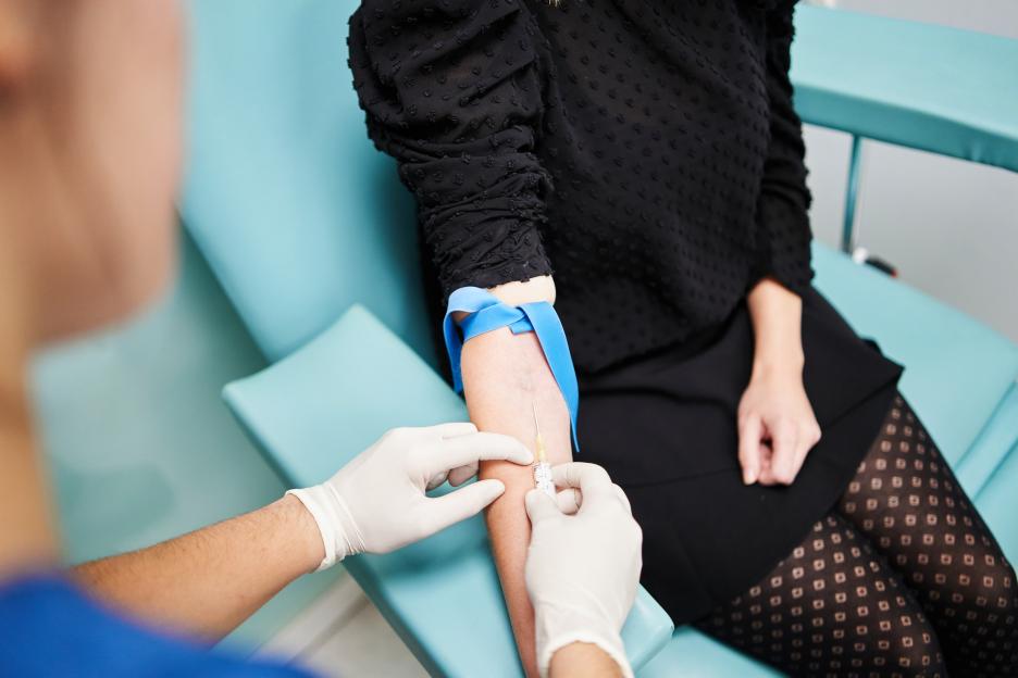 Medical professional drawing blood from a patient's arm.