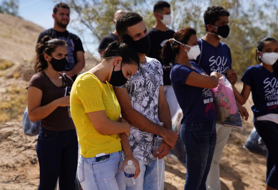 Migrants wearing face masks are detained by CBP agents after crossing the border from Mexico into Calexico, California.