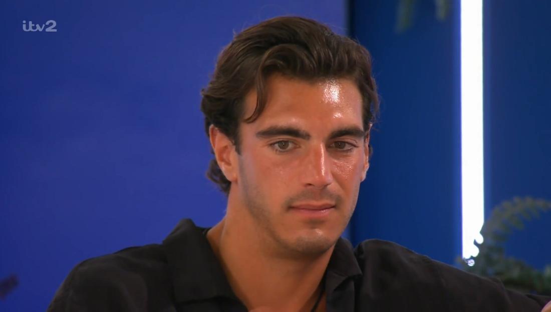 Lorenzo from Love Island, with a pained expression, looking at Julia.
