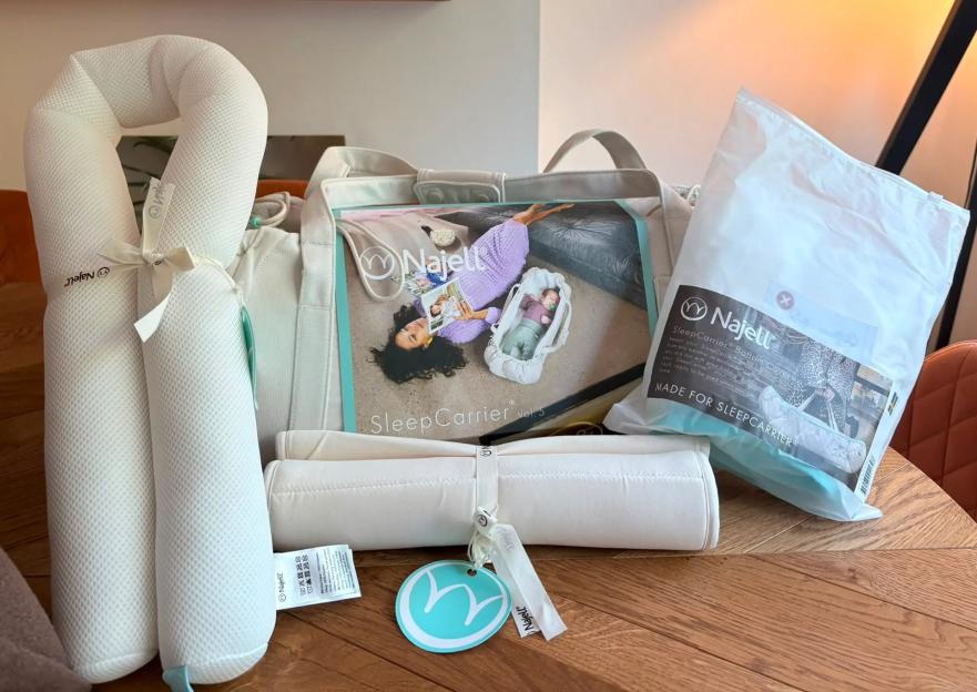 Najell SleepCarrier baby products including a neck pillow, rolled mattress, and carrier bag.