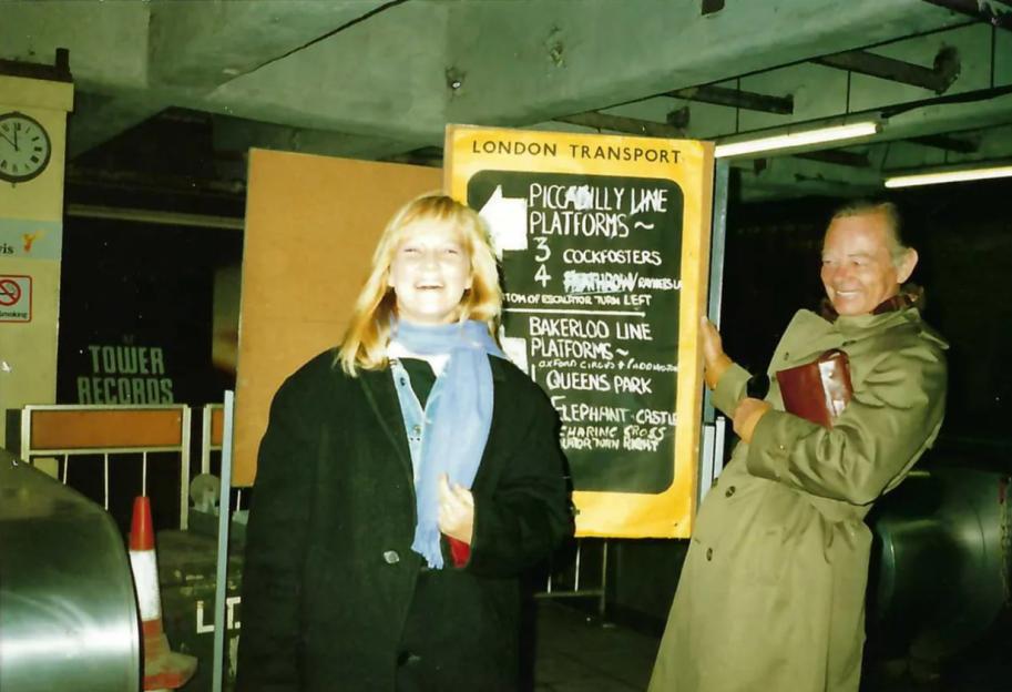 two people standing next to a sign that says piccadilly lane platforms